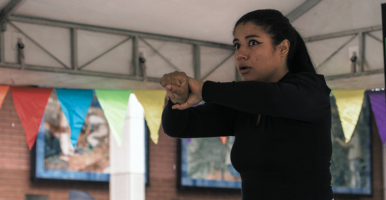 Estudiantes conversan en un círculo sentados en el suelo de un salón