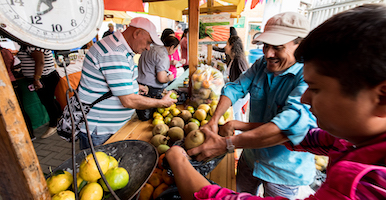 Plano general de una plaza de mercado, con campesinos intercambiando productos