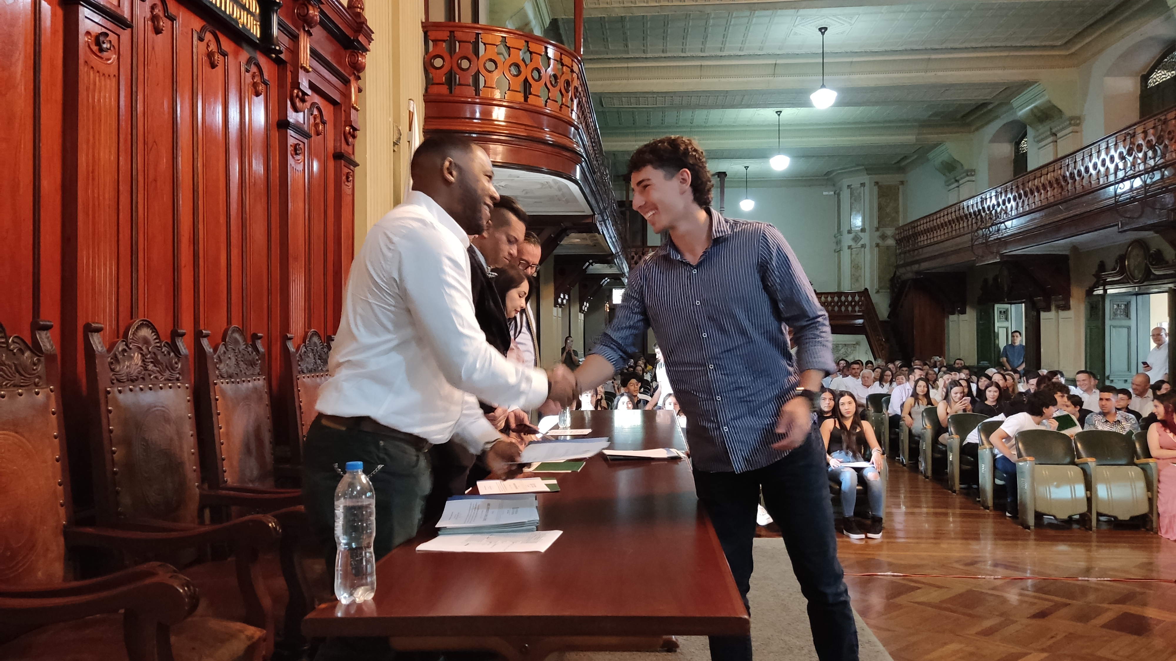 Certificaciones Multilingua en el Edificio San Ignacio. Estudiante y docente dándose la mano