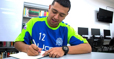 Un estudiante del Campus Sonsón escribiendo en una libreta