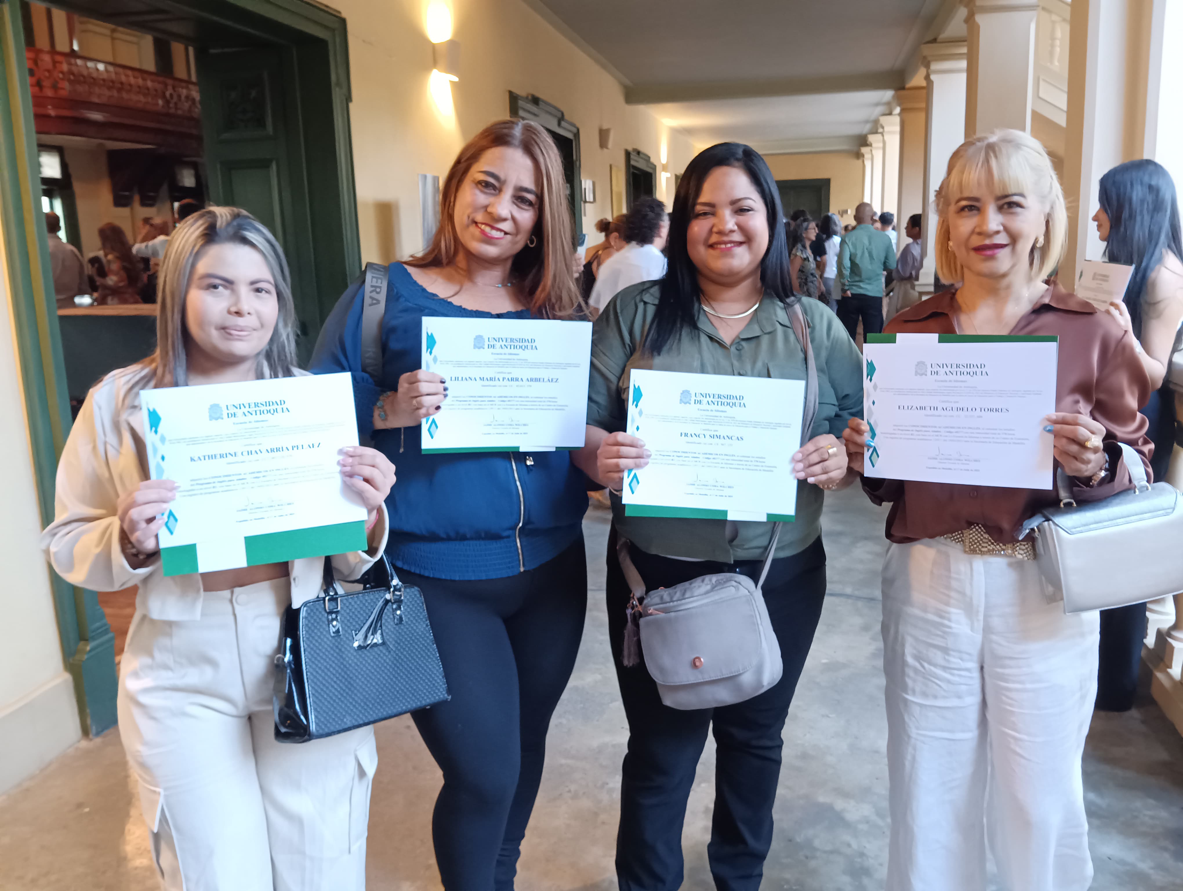 Estudiantes de pie con diplomas en las manos