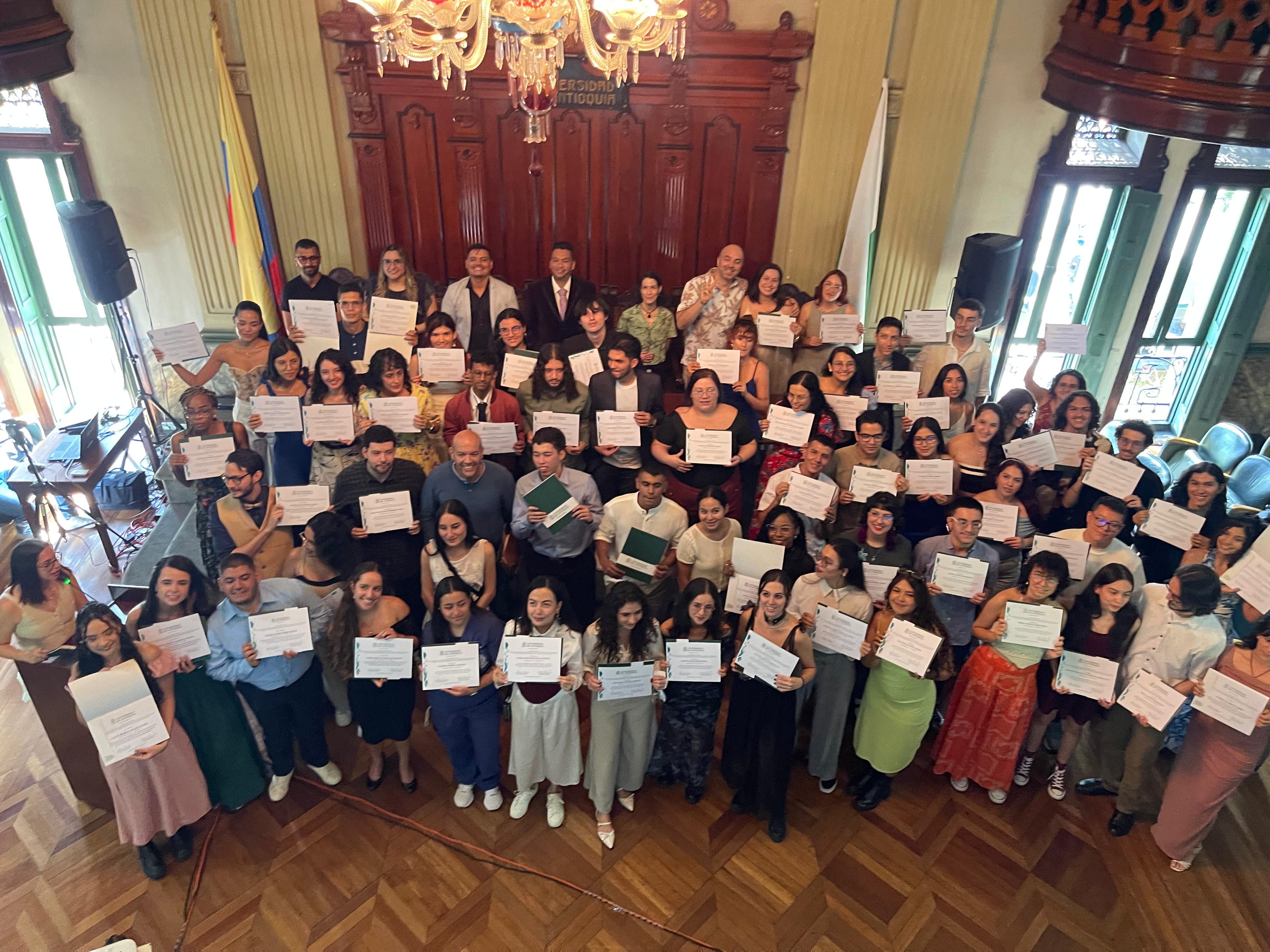 Estudiantes de pie con diplomas en las manos