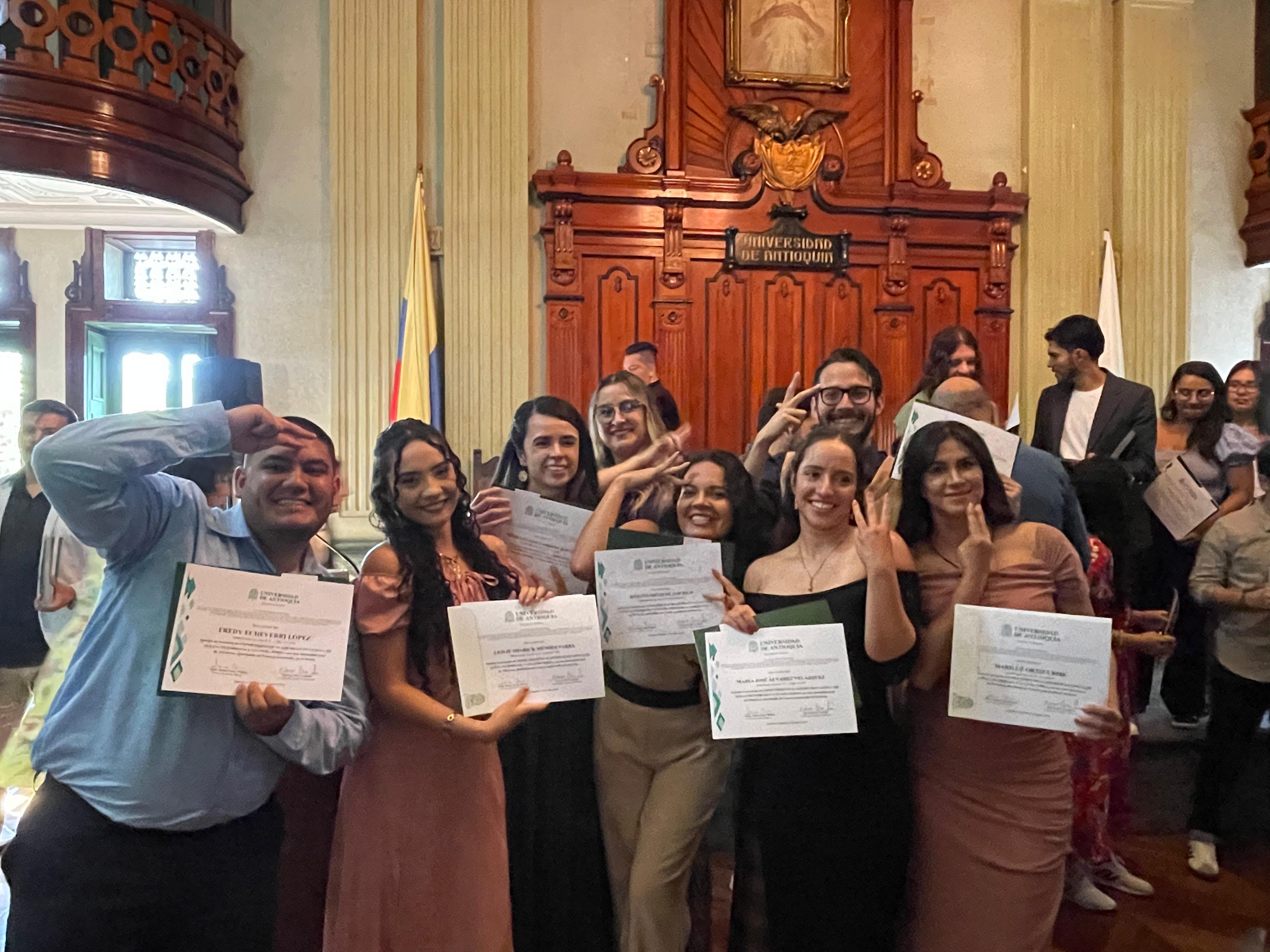 Estudiantes de pie con diplomas en las manos