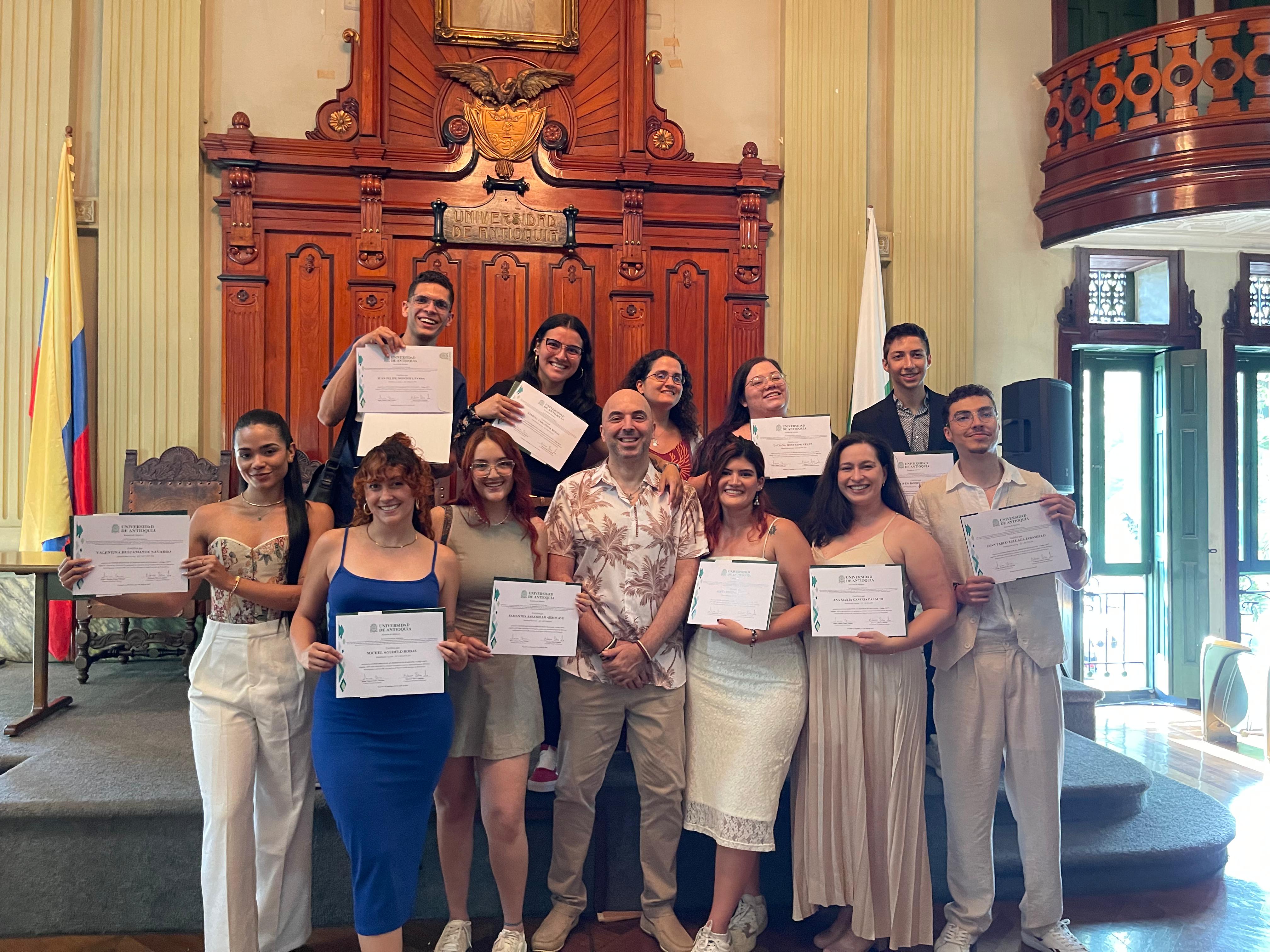 Estudiantes de pie con diplomas en las manos