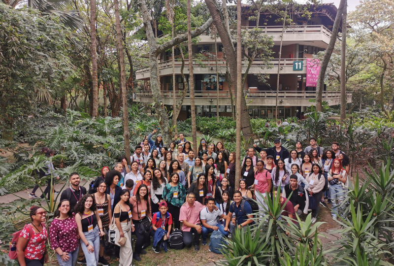 Fondo fachada Escuela de Idiomas rodeada de árboles. Personas en el Encuentro Nacional RedPolidiversa.