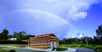 Imagen de la portería del campus El Carmen de Viboral con un arcoiris sobre ella