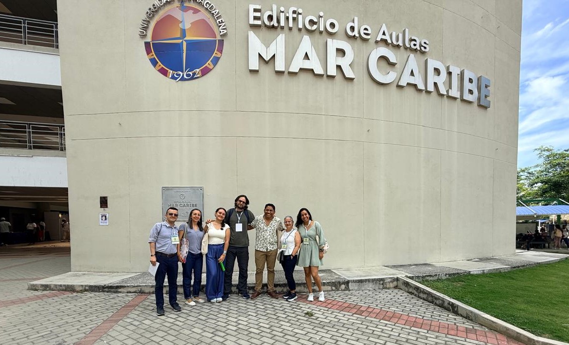 Profes y estudiantes de la Escuela de Idiomas de pie frente al edificio de aulas Mar Caribe en Santa Marta_ASOCOPI Profes y estudiantes de la Escuela de Idiomas de pie frente al edificio de aulas Mar Caribe en Santa Marta_ASOCOPI