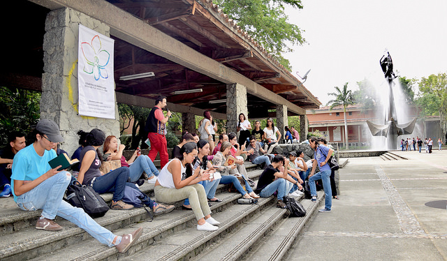 Varios estudiantes sentados en una escales de la plazoleta Barrientos