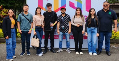 Semilleristas del campus El Carmen de Viboral sonriendo a la cámara con el backing del Encuentro Departamental de Semilleros de Investigación 2025