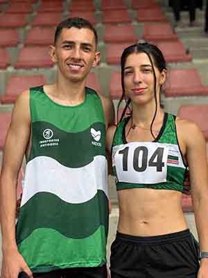 Dos deportistas de pie en premiación de atletismo