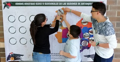 Un grupo de personas señalando un mapa de los campus regionalizados de la Universidad de Antioquia