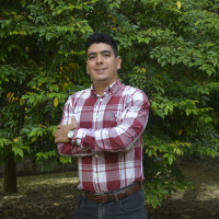 Foto del profesor Edwin. Tiene una camisa blanca y roja de cuadros.