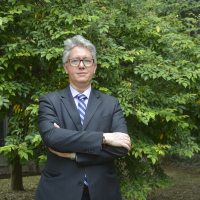 Foto del profesor Wilman. Tiene traje y una corbata azul de rayas.