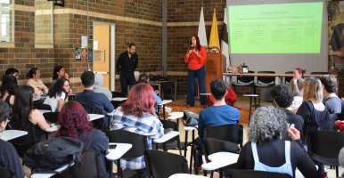 Tres íconos de siluetas de personas y una mano señalando al ícono de la mitad.