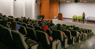 Tres íconos de siluetas de personas y una mano señalando al ícono de la mitad.